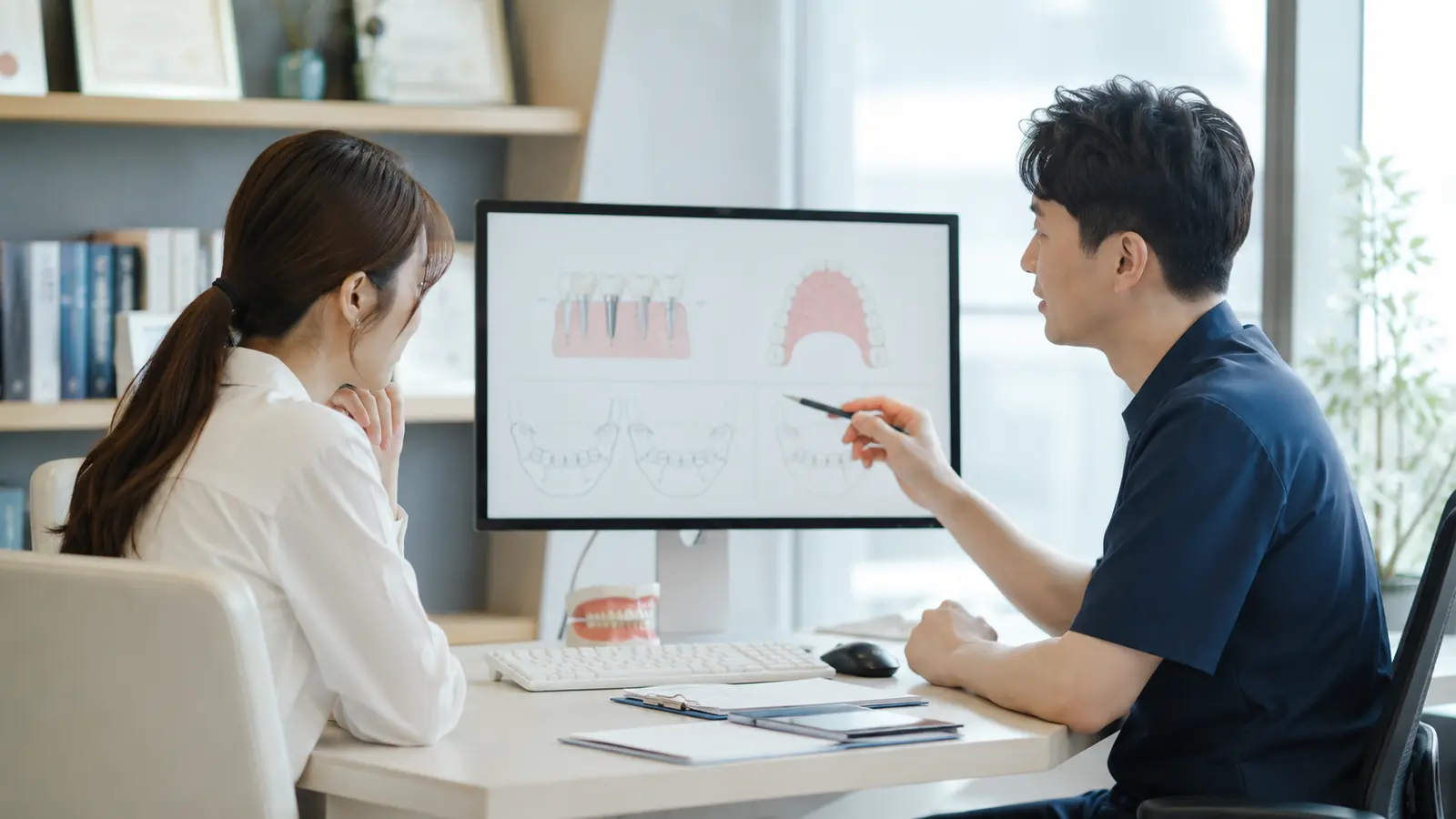 치과 상담에서 환자의 단계별 질문을 설명하는 의료진